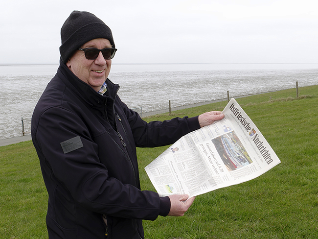 Ulrich Simons mit den Ostfriesischen Nachrichten auf dem Deich bei Neuharlingersiel